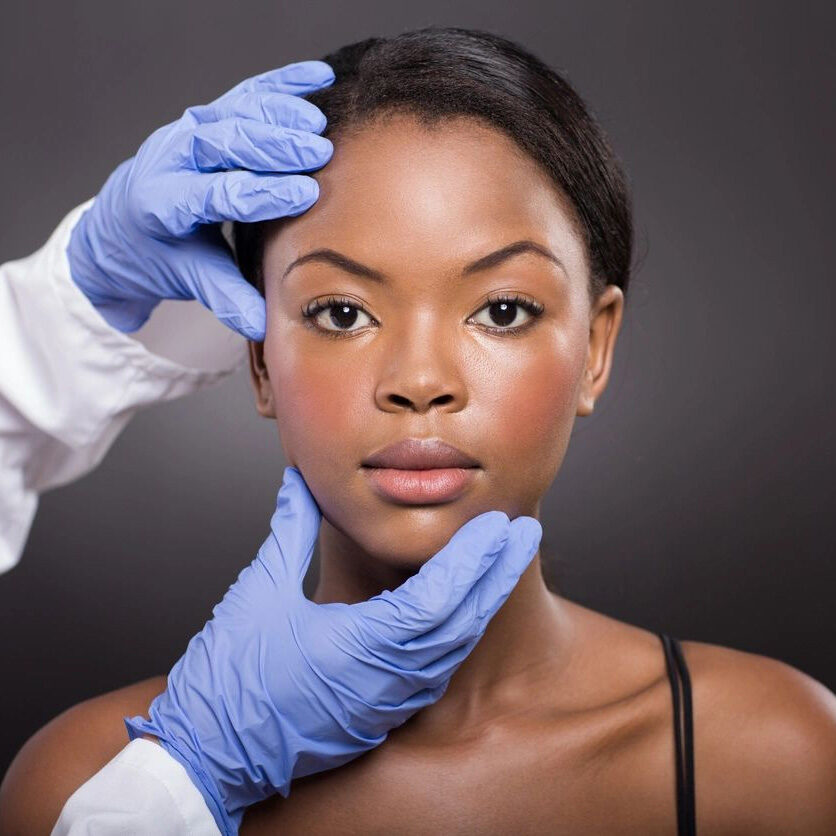 A woman getting her face examined by an expert.