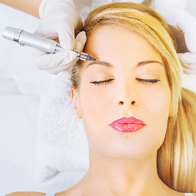 A woman getting her eyebrows threaded by an esthetician.